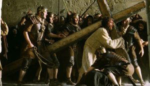 Jim Caviezel portrays Christ with his cross in a scene from the movie "The Passion of the Christ." The film, produced and directed by Mel Gibson, is a vivid depiction of the last hours of the life of Jesus. It received an R rating from the Motion Picture Association of America for sequences of graphic violence. (CNS photo from Icon Productions) (Feb. 24, 2004) See MOVIE REVIEW to come.